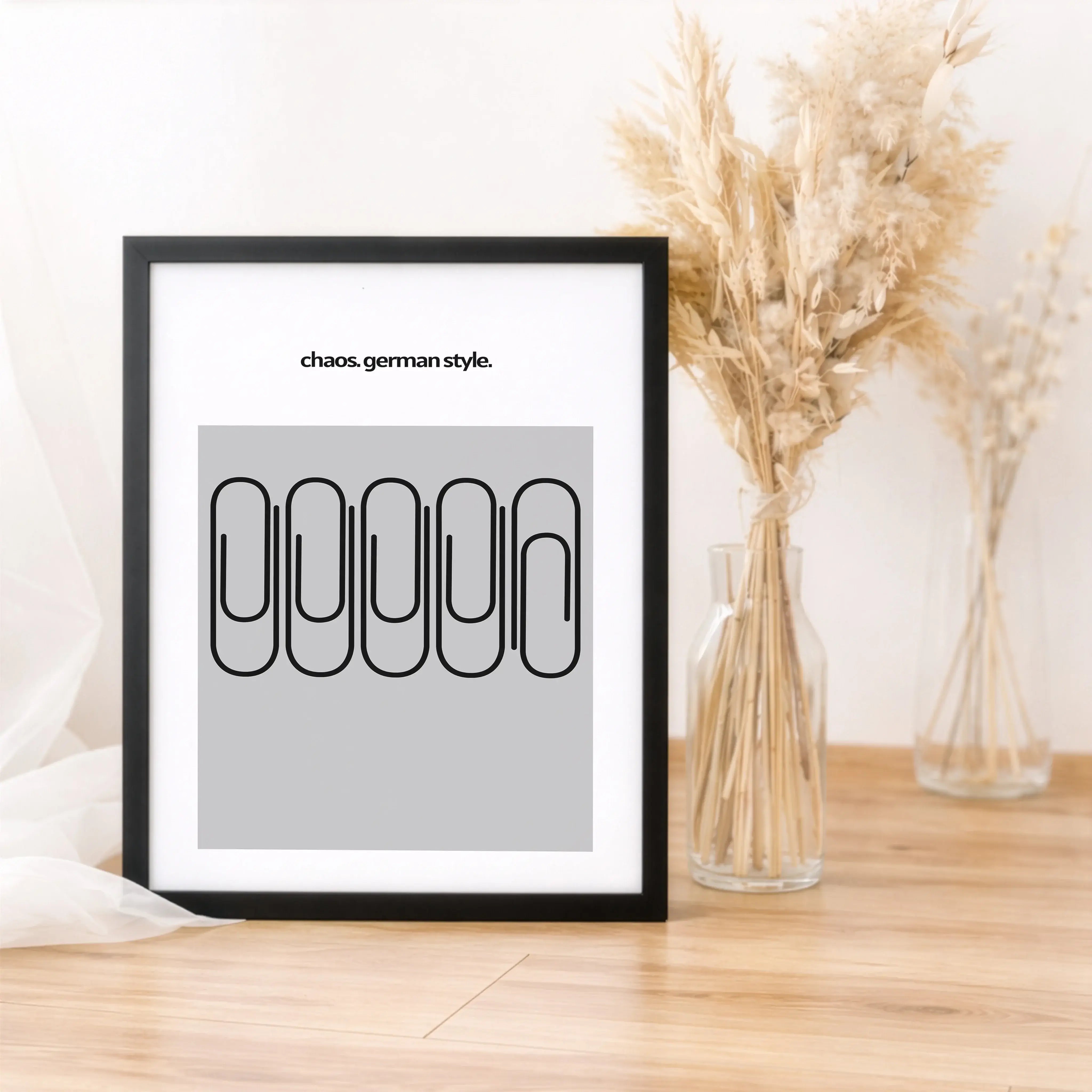 Chaos German Style Poster-Poster-famprints-Das Chaos German Style Poster bringt trockenen Humor, klares Design und ein Augenzwinkern an deine Wand. Fünf Büroklammern, sauber angeordnet – und doch ist eine anders. Genau dieses kleine Detail macht den Witz