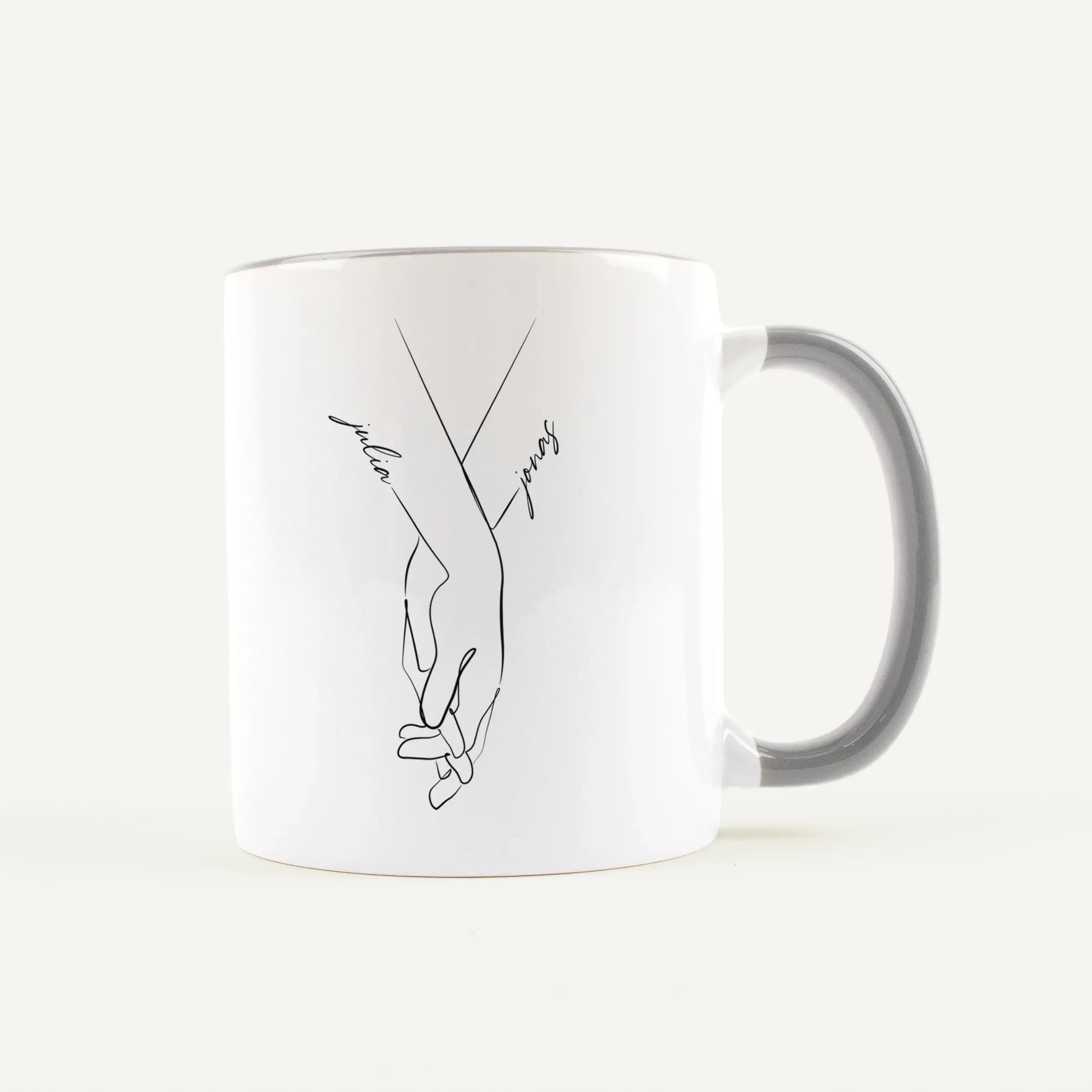 Tasse Hand in Hand-Keramik Tasse-famprints-Tasse Hand in Hand von famprints ist eine persönliche Tasse für Paare, die ein schlichtes Motiv mit Bedeutung suchen. Zwei ineinandergreifende Hände stehen für Verbundenheit, während die Namen direkt in das Desig