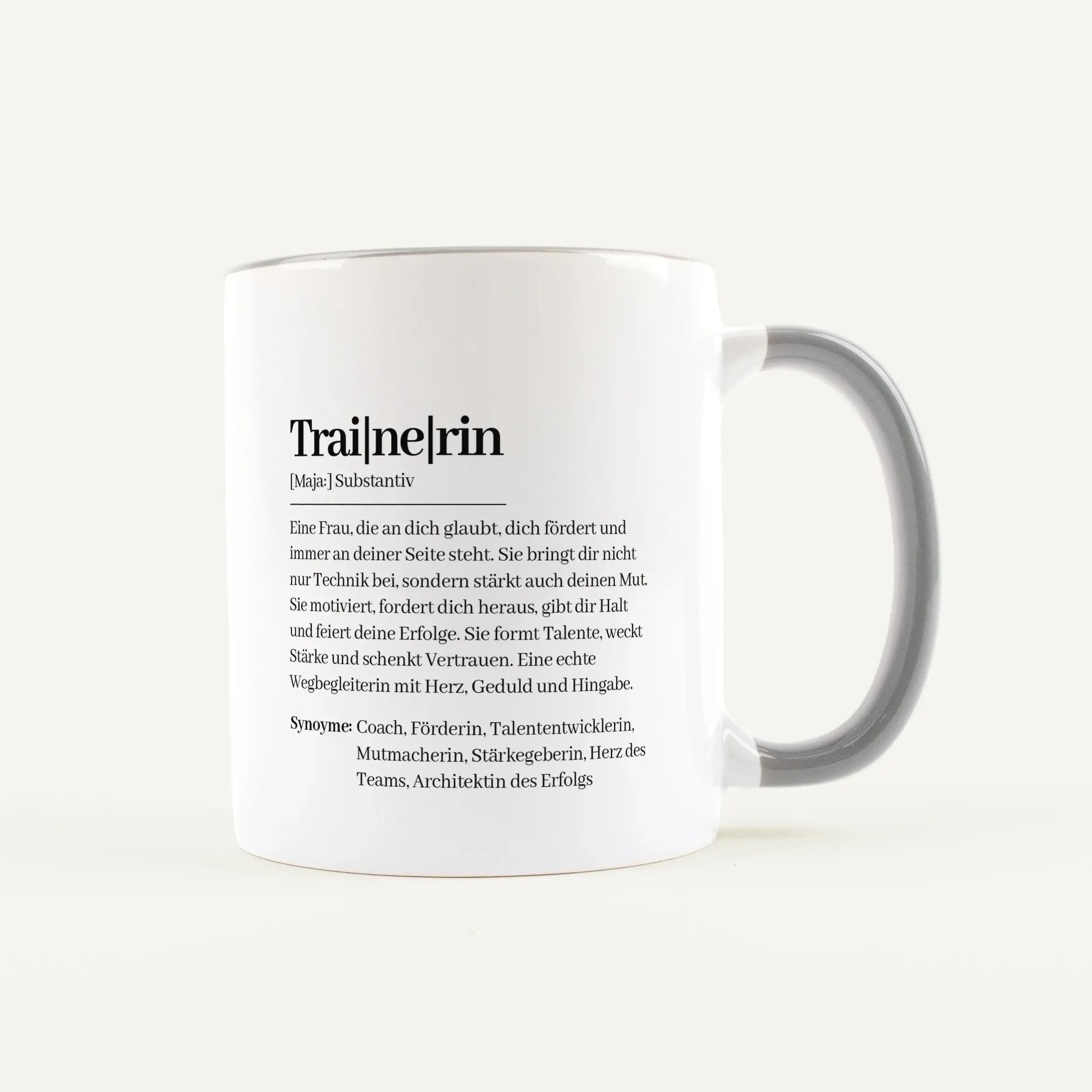 Tasse Definition Trainerin-Keramik Tasse-famprints-Die Tasse Definition Trainerin ist eine liebevolle Geschenkidee für einen Menschen, der fördert, motiviert und immer an andere glaubt. Das Design im Duden Stil macht aus einer einfachen Tasse eine persönl