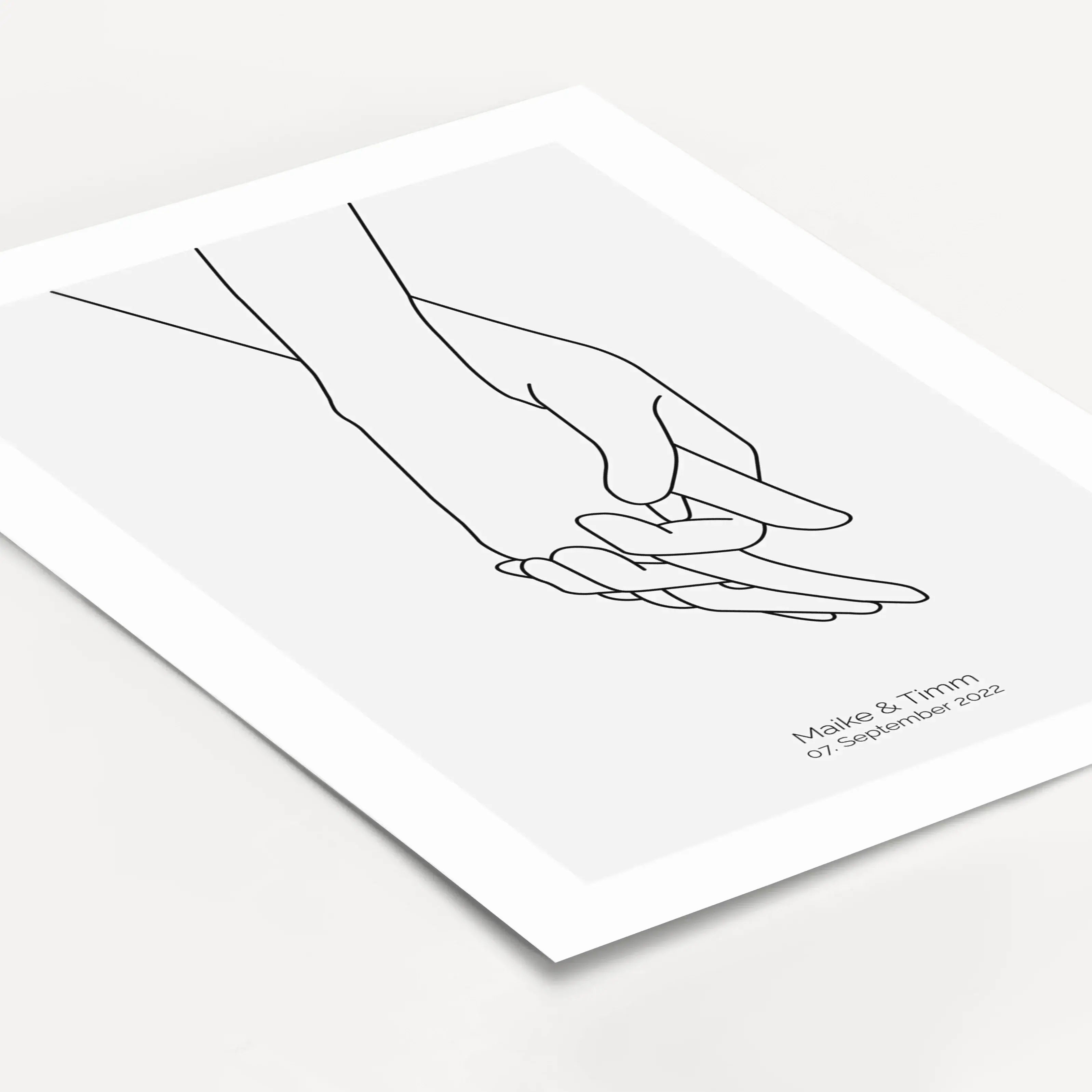 Poster 'Hände Line Art'-famprints-Personalisiertes Poster-Auf dem Poster 'Hände Line Art' in grau befindet sich die schwarze Kontur von zwei ineinandergreifenden Händen. Darunter kann das Poster mit deinem Wunschtext personalisiert werden. In unserem Beis