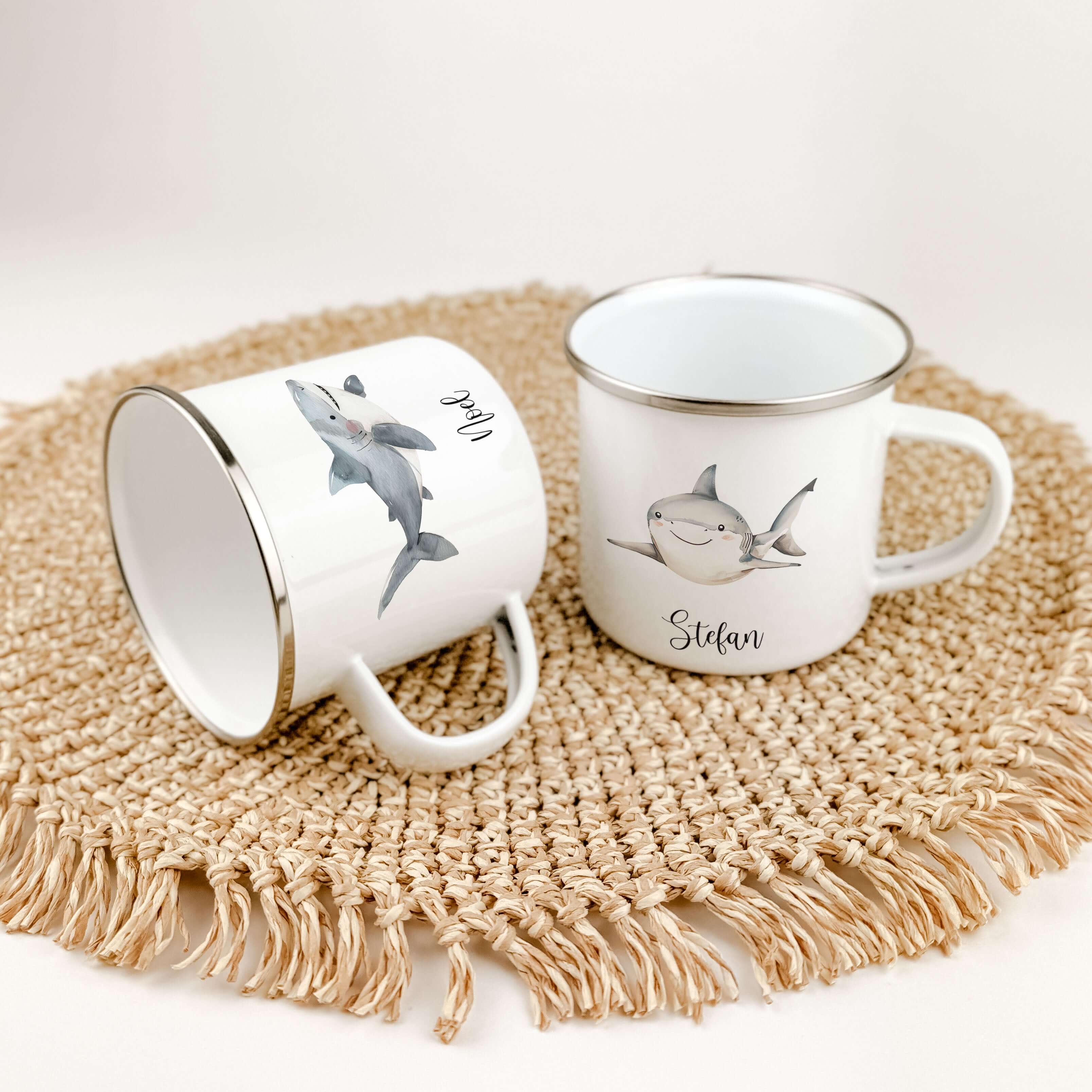 Emaille Tasse Hai-famprints-Emaille Tasse-Entdecke die perfekte Kindertasse für kleine Abenteurer! Unsere personalisierte Emaille Tasse mit einem bezaubernden Hai-Motiv in Aquarell-Optik bringt nicht nur Freude, sondern auch ein Stück Unterwasserwelt dire